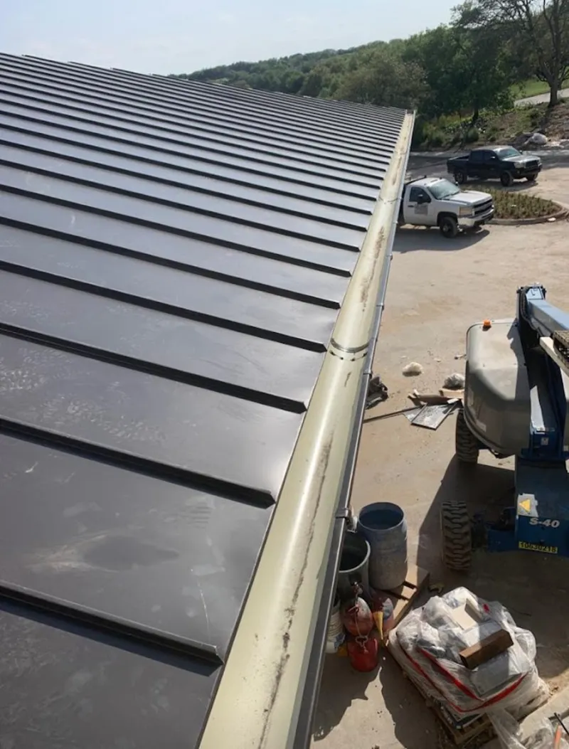 Standing seam panel and gutter detail on a metal roofing jobsite in Woonsocket